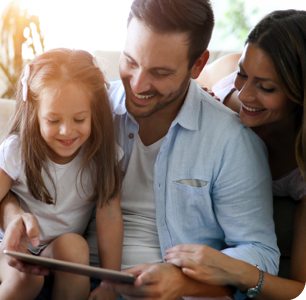 Image of smiling daughter, father, and mother all looking at a tablet in the father's hands