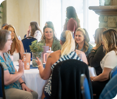 Image of a table of Mainstream Fiber employees smiling and talking to one another