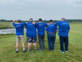 Golfers showing their shirts with Mainstream sponsorship for Blue River Services Golf Scramble